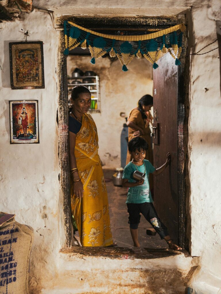 An intimate look at an Indian family standing by their home's traditional entrance.