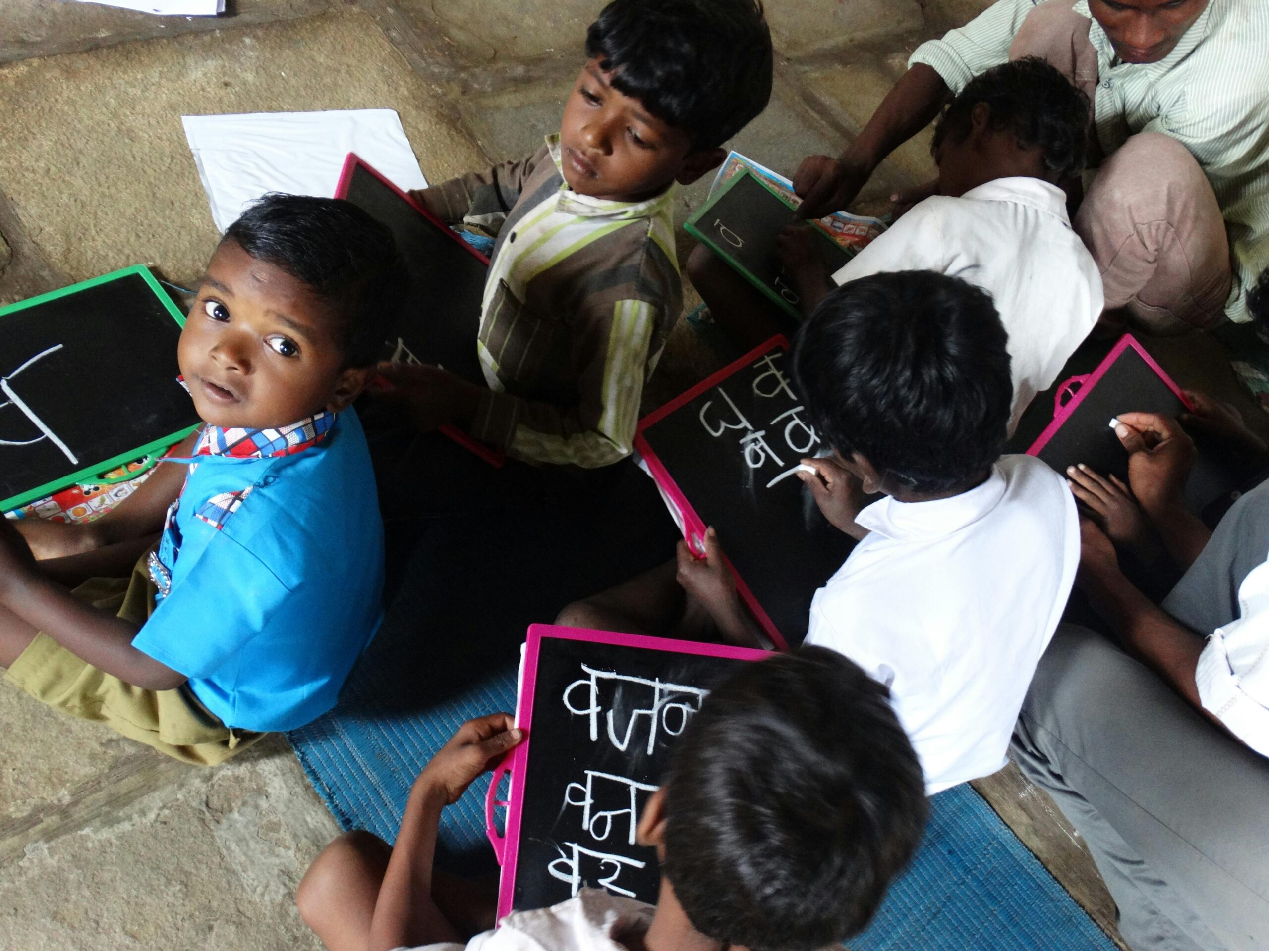 Young students writing on slates in a village school in Melghat, India.